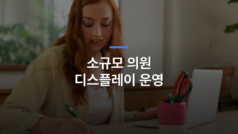 소규모 의원 디스플레이 운영 글 대표이미지 · 배경 사진: Woman with red hair writing on paper at home office desk with a laptop.